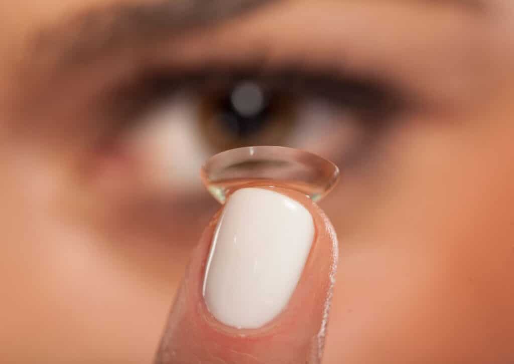 Contactlens op de vingertop vlak voor het oog
