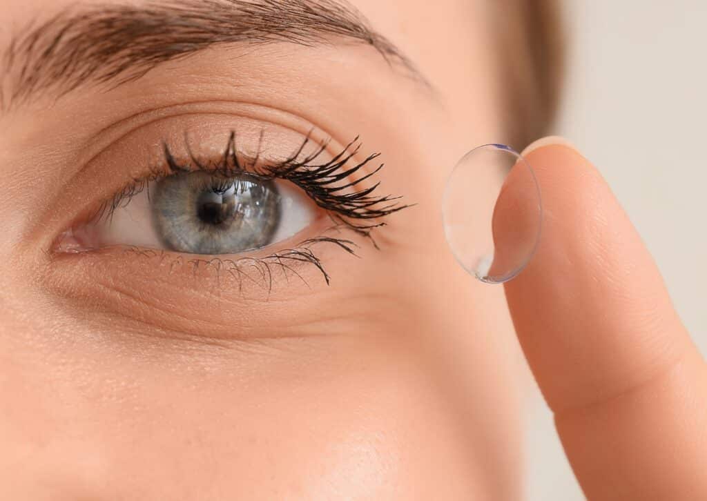 Vrouw zet een zachte contactlens in, close-up van het oog en de wimpers